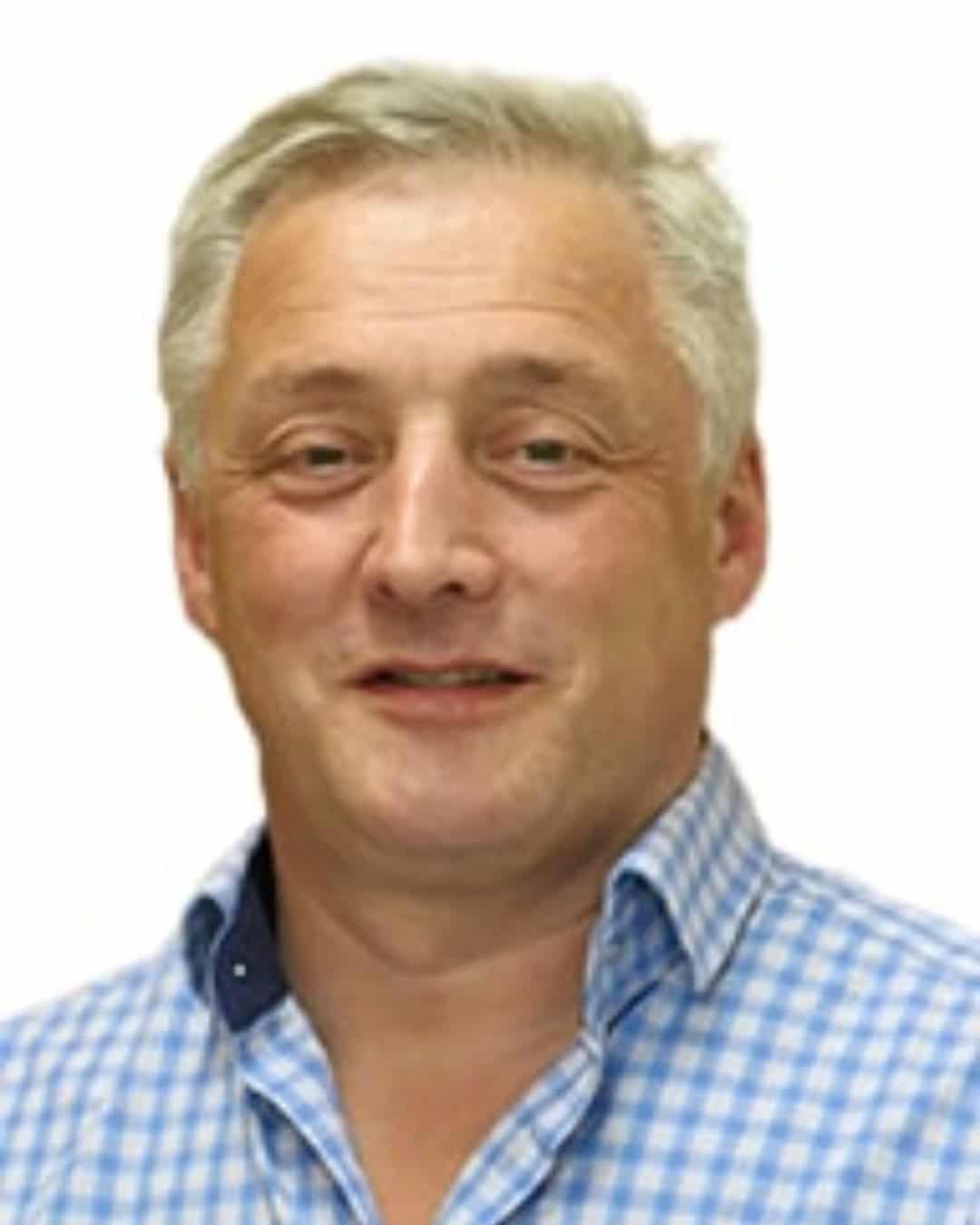 Stuart Rivers A middle-aged man with short, grey hair is smiling slightly. He is wearing a blue and white checked shirt and is photographed against a plain white background.